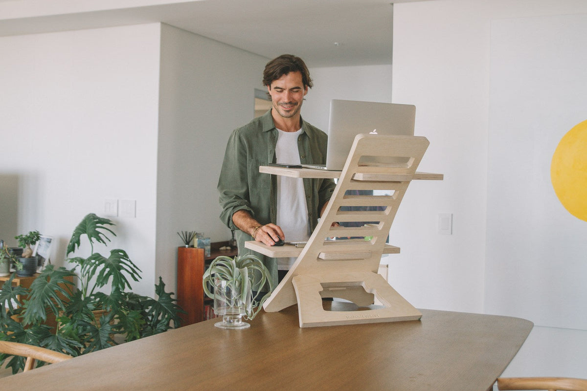 Wood standing desk shown at an adjustable working height